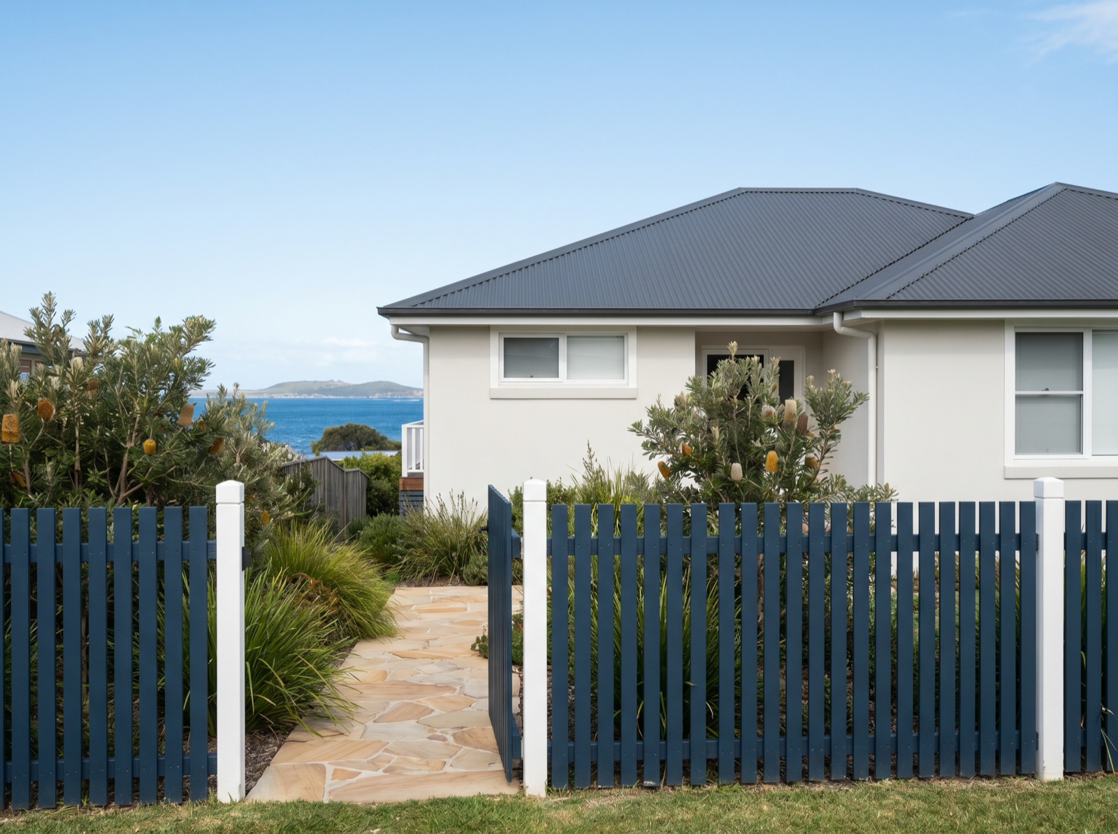 Exterior repaint with navy timber-paling fence in Narooma
