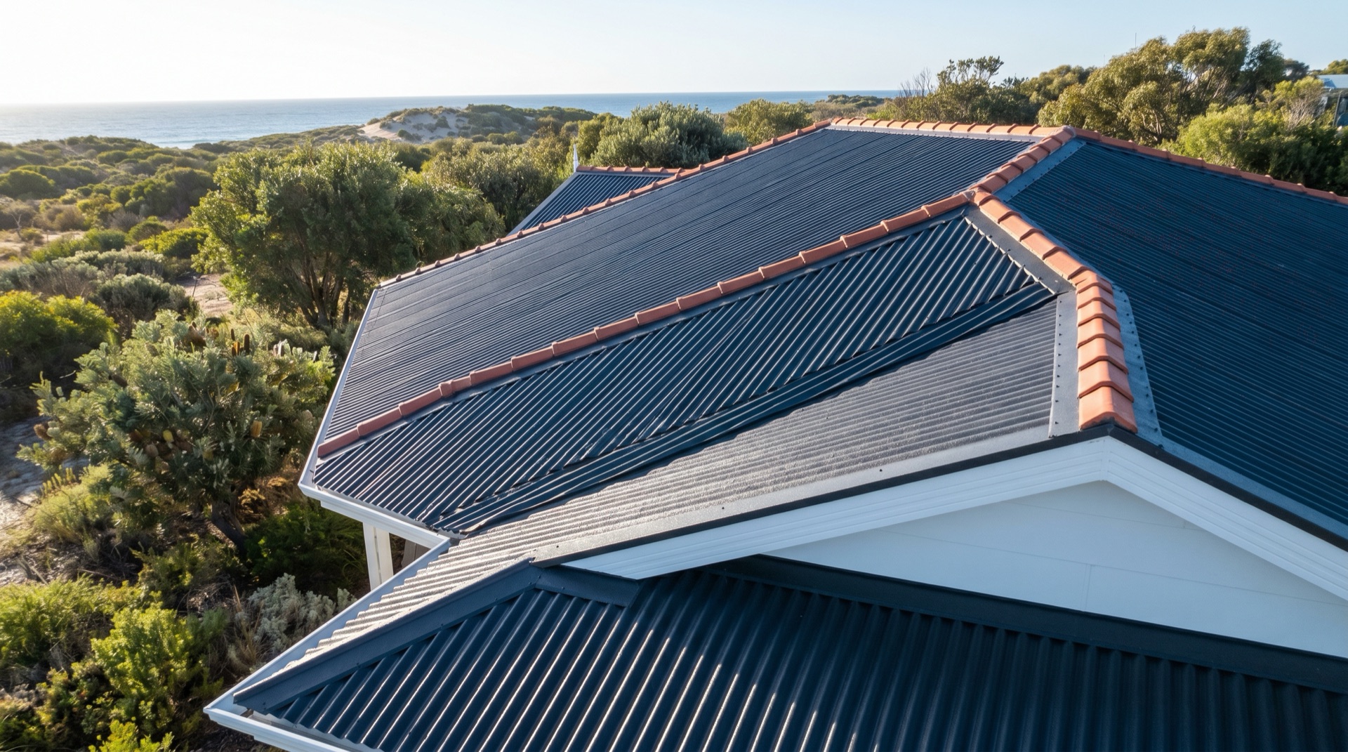 Charcoal Colorbond and terracotta tile roof restoration with crisp white gutters